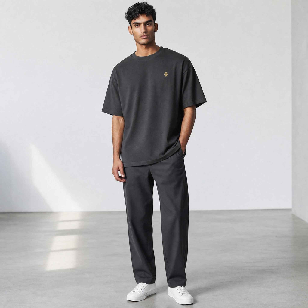 VVID Essential Oversized Tee in charcoal grey, featuring a small gold embroidered logo on the chest. Relaxed fit, crew neck, short sleeves.