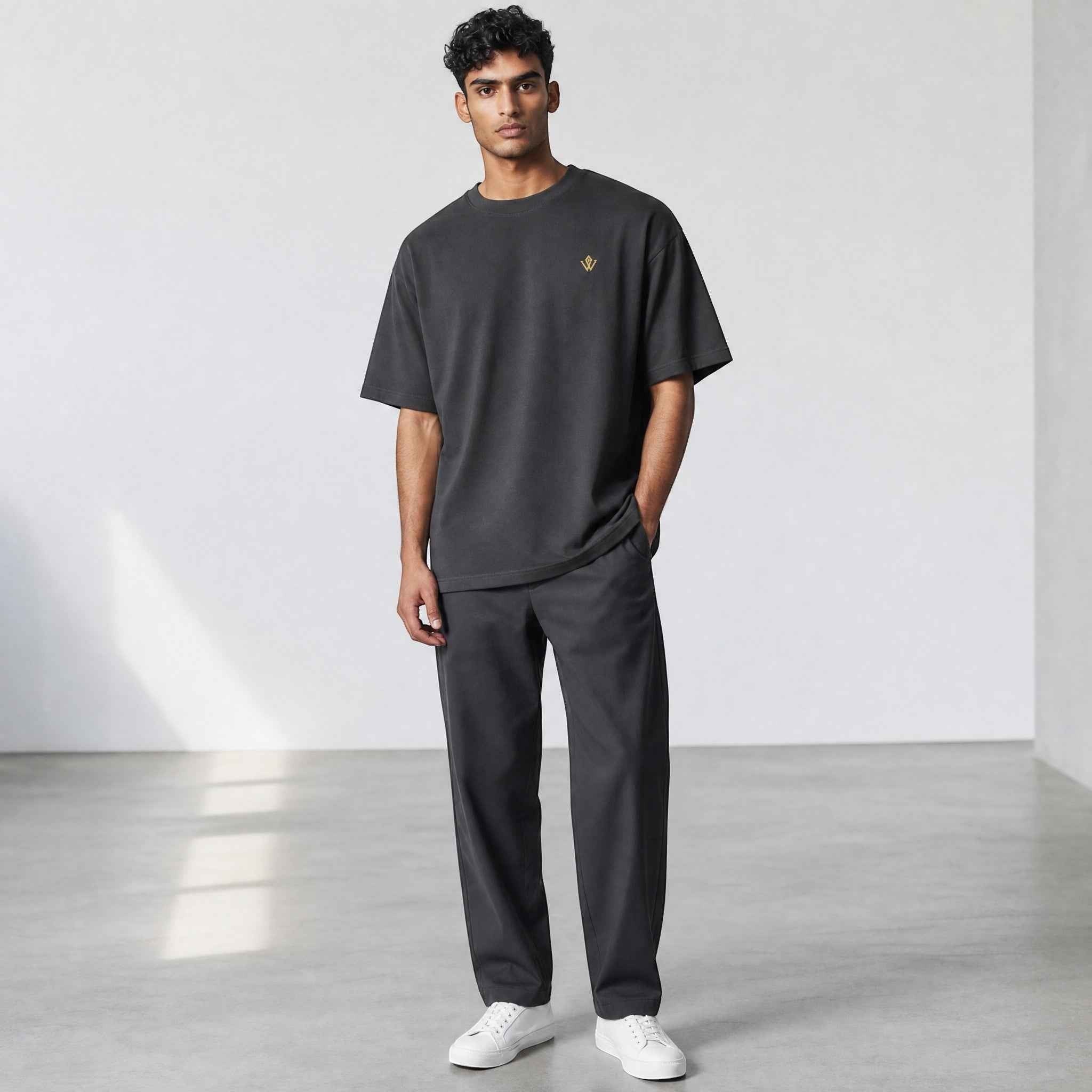 VVID Essential Oversized Tee in charcoal grey, featuring a small gold embroidered logo on the chest. Relaxed fit, crew neck, short sleeves.